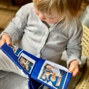 Bébé 12 mois qui lit un livre doudou