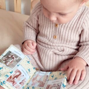 Bébé 8 mois qui lit un livre doudou